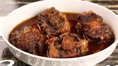 some meatballs are in a white bowl on a table