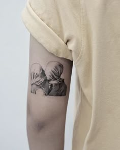 a woman with a tattoo on her arm is holding a man's head in the shape of a heart