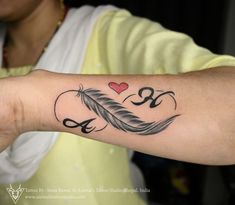 a woman's arm with a tattoo on it that has an arrow and a heart