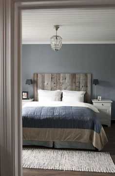 a bedroom with a bed, nightstands and a chandelier