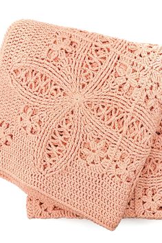 two pink crocheted blankets folded on top of each other, one with an intricate design