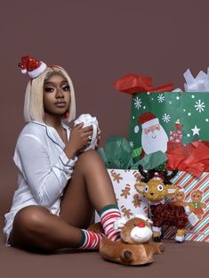 a woman sitting on the floor next to presents