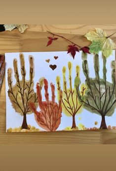 an art project with watercolors on paper and leaves in the shape of trees