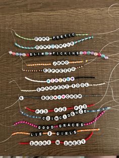 several different types of beaded bracelets are arranged on a wooden table with string