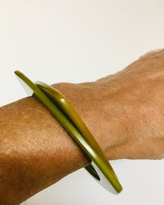 a person's arm with a green bracelet on it