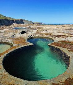 there is a large pool in the middle of some rocks with water running through it