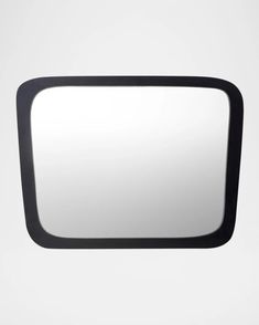 a black rectangular mirror on a white wall