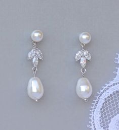 "Our lovely feminine Pearl and Crystal 'Hayley' Bridal Set comprises of drop earrings and a matching necklace for a ready-to-go set! Two styles of earrings are available. One is a pearl post for pierced ears and the other is a teardrop crystal post available in identical clip on. We have created Hayley using cz crystals in a 3 point leaf design connecting the Swarovski pearl drop with a pearl post for a classy and sophisticated bridal accessory. 💞 This set is with a bridal discount. 💙Available Pear-shaped Pearl Wedding Jewelry, Wedding Jewelry With Matching Pear-shaped Earrings, Pearl Wedding Jewelry Sets, Bridal Jewelry Pearl Sets, Pearl Bridal Earrings, Feminine Wedding, Wedding Studs, Crystal Pearl Earrings, Pretty Jewelry Necklaces