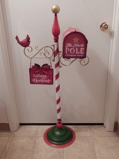 a red and white pole with a mailbox on it in front of a door