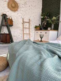 a bed in a room with white brick walls and green bedspread on it