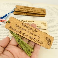 a hand holding two bookmarks that say thank you for being part of our story