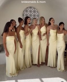 a group of women standing next to each other in long yellow dresses and smiling at the camera