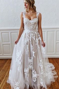 a woman in a wedding dress standing on a wooden floor