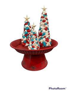 two red, white and blue christmas trees on top of a red cake plate with stars