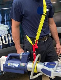 a man is holding a blue and yellow hose connected to a fire extinguisher