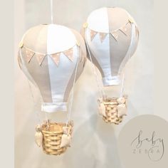 two white hot air balloons hanging from strings