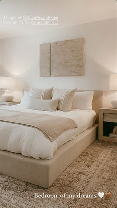 a large white bed sitting in a bedroom next to two lamps on either side of the bed