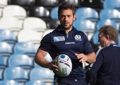 a man holding a rugby ball in his hands