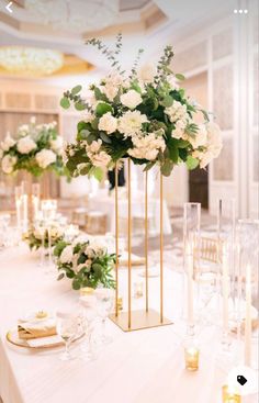 a long table with white flowers and candles on the top is set up for a formal function