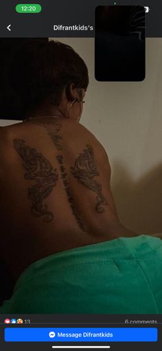 the back of a man with tattoos on his upper and lower half, sitting in bed