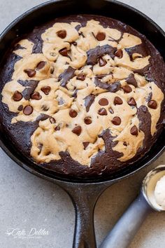 a chocolate chip cookie in a cast iron skillet with ice cream on the side