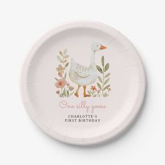 a white paper plate with a duck and flowers design on it that says, one silly goose charlotte's first birthday