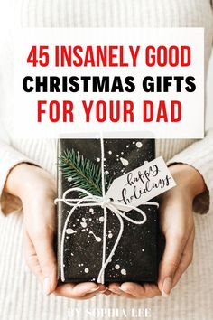 a person holding a present wrapped in black paper with the words, 45 insanely good christmas gifts for your dad