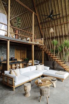 a living room filled with lots of furniture next to a spiral stair case on the wall