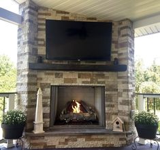 an outdoor fireplace with a flat screen tv above it