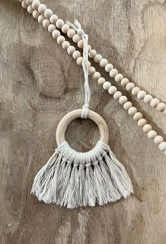 a wooden beaded necklace with tassels hanging from it