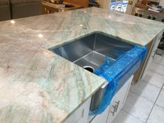 a kitchen counter with a sink in the middle and blue tape on it's edge