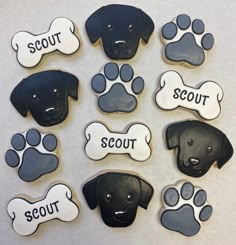 dog cookies decorated with black and white icing, paw prints and words on them