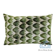 a green and white pillow with an abstract design on the front, sitting on a white background