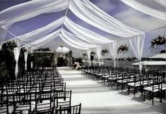 an outdoor wedding setup with white draping and chairs