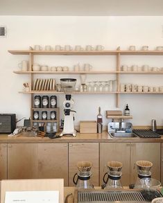 a coffee shop with wooden shelves filled with cups and saucers on top of them