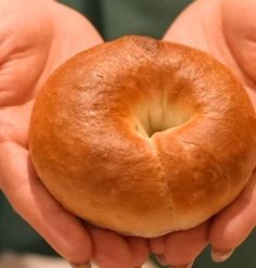 a person holding a bagel in their hands