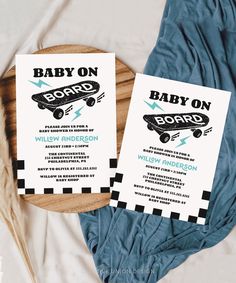 two baby on board cards sitting on top of a wooden tray next to a blue blanket