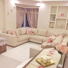 a living room filled with lots of furniture and flowers in vases on the coffee table