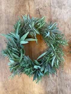 a wreath made out of fresh herbs on a wooden table