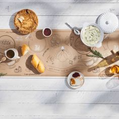 an overhead view of food and drinks on a wooden board with white wood flooring