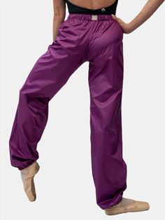 a woman in purple pants is standing on one leg