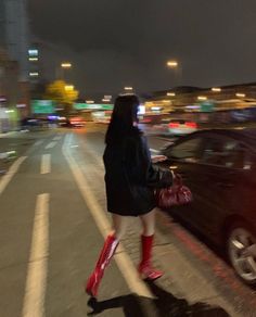 a woman in red boots crossing the street