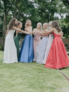 a group of women standing next to each other holding hands