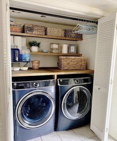 a washer and dryer in a room with open shelves on the wall next to each other