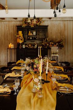 a dining room table is set with yellow cloths and place settings for dinner guests