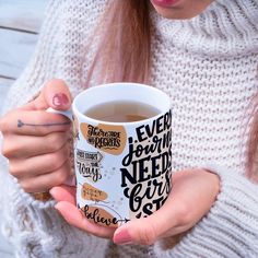 a woman holding a cup of coffee in her hands with writing on the inside and outside