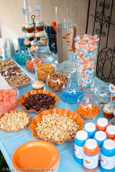 a table topped with lots of food next to cups and containers filled with candy bars