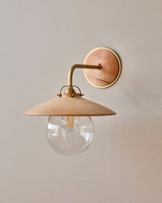 a light fixture mounted on the side of a white wall next to a lamp bulb