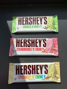 three hershey's candy bars sitting on top of a black table next to each other