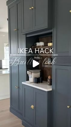 a kitchen with dark gray cabinets and white counter tops in the center is an open pantry